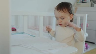 Genç bir çocuk, evinde canlı yaratıcılığını ve sanatsal becerilerini keşfederken özenle çizim yapmaya odaklanır.