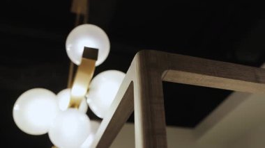 Tahta mobilyalar ve dört posterli yatak elementleri. Yakın plan ve odunların ayrıntıları. Modern ışıklandırma ve şık mobilyalar lüks bir atmosfer ve sanatsal cazibe yaratır. Yüksek kalite 4k görüntü