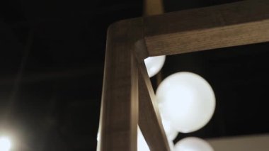 Arkaplanda herhangi bir alan için dört posterli ahşap bir yatak ve eşsiz küresel ampuller yakın plan. Yüksek kalite 4k görüntü