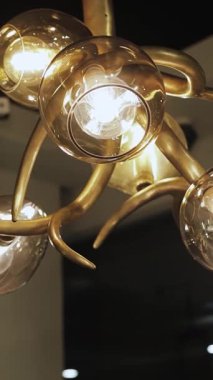 Dikey çekim. Altın işlemeli bir avizeye yakın plan ve güzel el yapımı cam toplar. Yüksek kalite 4k görüntü