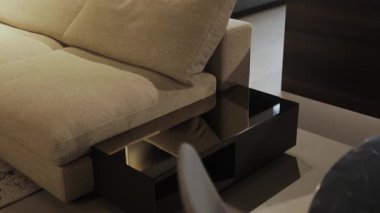 Modern ve çağdaş bir kanepe, tasarım ve konforun gerçek zarafetini somutlaştıran parlak siyah bir kahve masası ile eşleştirilir.