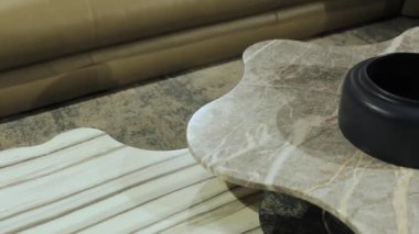 Bu şık kahve masasında çarpıcı bir mermer yüzey ve eşsiz tasarım elementleri sergileniyor.