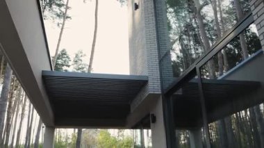 Çağdaş bir ev yapısı. Parlak tasarım elementleri içeriyor. Güzel bir şekilde yemyeşil ağaçlarla çevrili. Yüksek kalite 4k görüntü