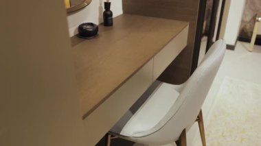 Bu modern masa düzeninde şık bir sandalye ve dekoratif eşyalar, çağdaş bir çalışma alanı oluşturur.