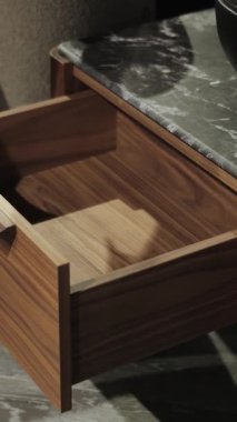 Dikey ekran: Bir kadının eli modern bir komodinin çekmecesini kapatır. Modern Oturma Odası 'nda Zarif Çekmece Açılışı Görsel Bir Görsel Deneyim Oluşturur. Yüksek kalite 4k görüntü