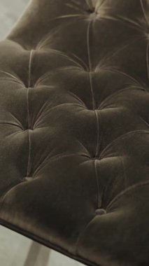 Dikey video. Şık bir kadife koltuğa yakın plan, bir sürü düğmesi var, modern bir iç mekan için mükemmel. Ağır çekim. Yüksek kalite 4k görüntü