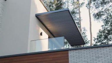 Camdan balkonlu, çatılı, doğa arka planlı özel bir evin modern mimari tasarımı. Modern mimari. Yüksek kalite 4k görüntü