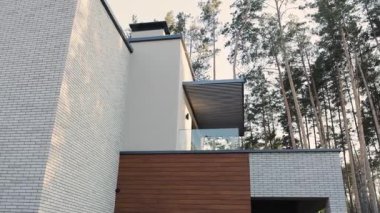 Modern mimari tasarım cam balkonlu, çatılı, yemyeşil ağaçlarla çevrili özel bir ev. Modern mimari. Yüksek kalite 4k görüntü