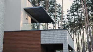 Bu şık ev dizaynı, güzel bir orman zemininde yer alan ahşap ve tuğla elementlerin karışımını içeriyor.