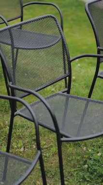 Tarz sahibi siyah örgü sandalyeler çimenlerin üzerinde güzelce yerleştirilmiş, açık hava toplantıları, piknikler ve rahatlama için ideal.