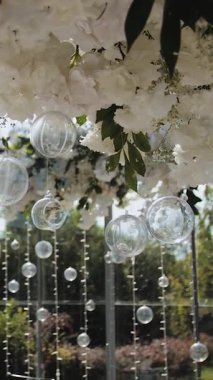 Dikey video. Düğün ya da etkinlikte bir restoranda çiçek aranjmanı. Etkinlik, dekore edilmiş masalar, süslü ziyafet salonu. Masanın üstünde güzel bir çiçek aranjmanı. Yüksek kalite 4k görüntü