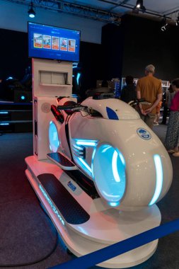 Mar 22 2025, Bangkok Tayland: Etkileşimli ekranları keşfeden ziyaretçilerin katıldığı bir teknoloji sergisinde fütüristik motosiklet simülatörü