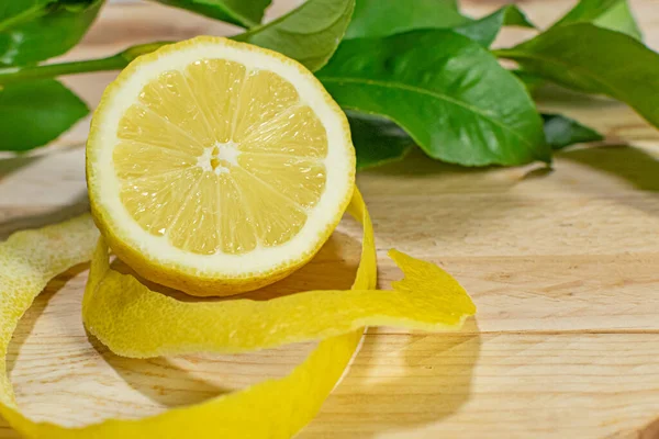 Tahta bir masada yaprakları sıralanmış doğal, taze ve sağlıklı limonlar.