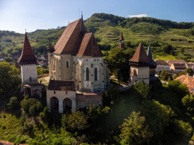 Aerial view drone of a medieval fortified church of Biertan nestled in a charming village, surrounded by rolling green hills. Romania. Copyspace. clipart