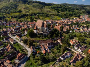 Yeşil tepelerle çevrili büyüleyici bir köyde, Biertan 'ın ortaçağ güçlendirilmiş kilisesinin nefes kesici hava manzarası. Romanya. Kopyalama alanı.