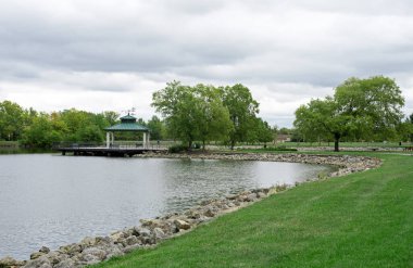 Şehir parkı göleti ve barınak üzerinde uğursuz bulut örtüsü ile dolu bulutlu bir gün.