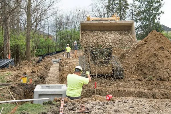 Dayton Ohio April 2024 Bauarbeiter Steht Entwässerungsgraben Während Kies Als lizenzfreie Stockfotos