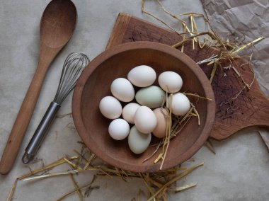 Tahta bir kase Bantam yumurtası ve saman.