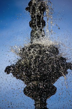 Mavi gökyüzü arka plan üzerinde çeşme su sıçrama