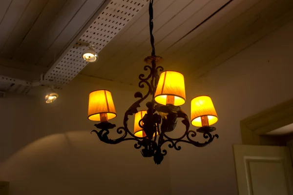 Glowing lamp on the ceiling in dark room