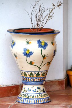 Fayanslı zeminde saksıda bitki var.