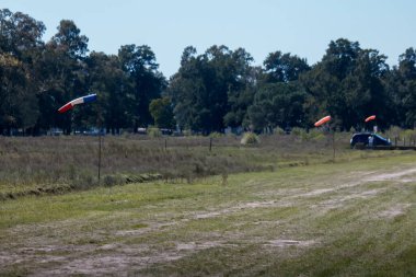 Arabası ve havada bayrakları olan bir tarla.