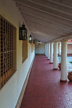 Kırmızı zemini ve beyaz duvarı olan uzun bir koridor.