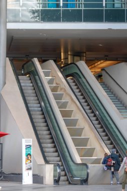 Bir grup insan yürüyen merdivende yürüyor.