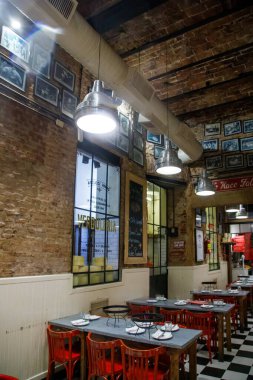 Masaları, sandalyeleri ve kareli zemini olan bir restoran.