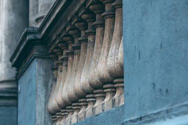 Balkonda dekoratif parmaklıkları olan bir bina.