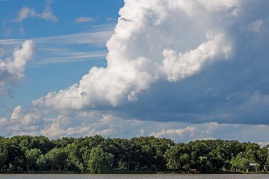 Gökyüzünün arka planında güzel bulutlar. Bulutlar su yüzeyine yansıyor.