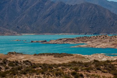 Arka planda dağ manzaralı bir göl.