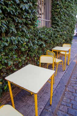 Eski kasabada boş kafeterya masaları ve sandalyeler