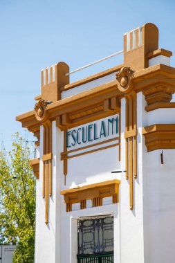 Bir binanın ön cephesi ve mavi gökyüzü olan yeşil ağaçlar.