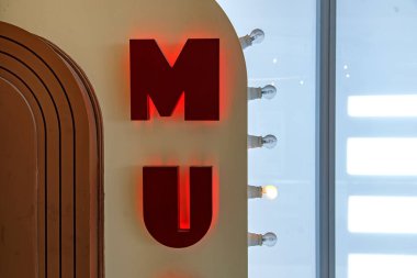 Duvarda kırmızı neon ışığı, MU mesajı