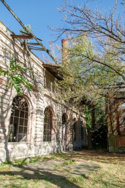 Pencerelerinde parmaklıklar olan terk edilmiş eski bina.