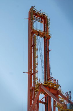 Mavi arka planda merdiveni olan kırmızı metal kule.