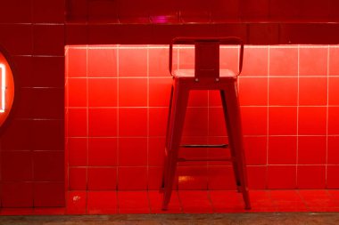 Barda kırmızı bir arka plana karşı kırmızı sandalye