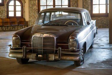 Klasik ayarlarda kapalı alanda gösterilen eski model bir araba.