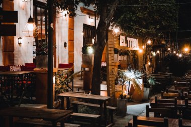 Sıcak ışıklı sokak kafesi olan bir şehir manzarası. 