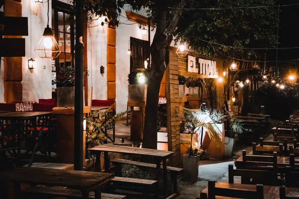 Sıcak ışıklı sokak kafesi olan bir şehir manzarası. 