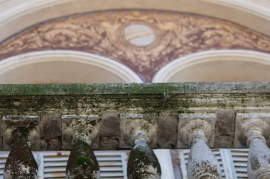 Yıpranmış taş sütunlar süslü kemerli cepheyi destekliyor