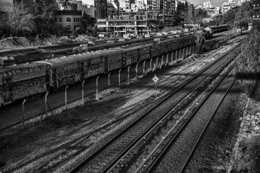 Terk edilmiş tren vagonları boş tren raylarının yanında duruyor.