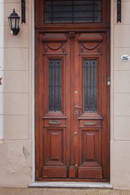 Siyah metal ızgaraları olan ahşap çift kapı.