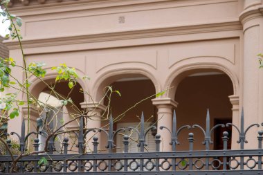 Kemerli pencerelerin, demir çitlerin olduğu tarihi bina cephesi