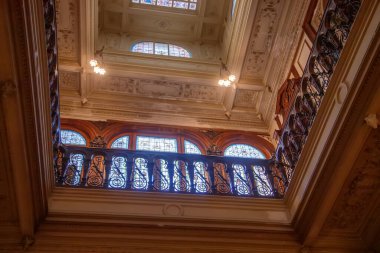 Süslü balkon korkuluklarına ve tavana doğru bakıyorum.