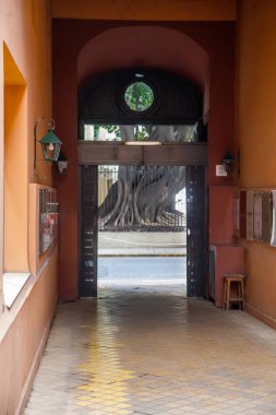 Açık kapıya doğru giden kemerli koridor.
