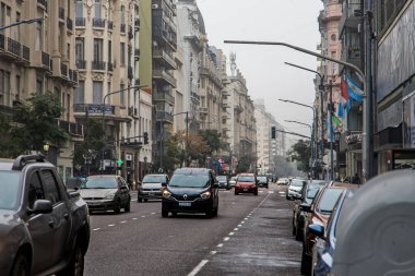 Gündüz vakti kalabalık şehir caddesinde araba sürüyor
