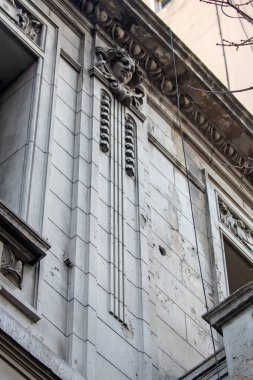 Süslü mimari detaylar içeren yıpranmış taş bina cephesi