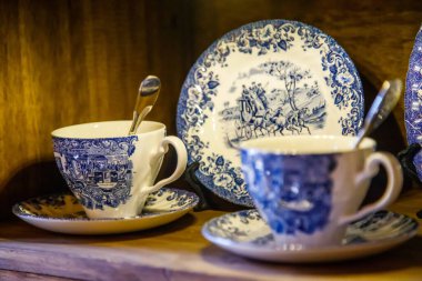 Eşleşen tabağın yanında duran klasik mavi çay fincanları.